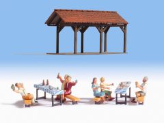 Cabanon tables bancs et personnages fête dans le jardin